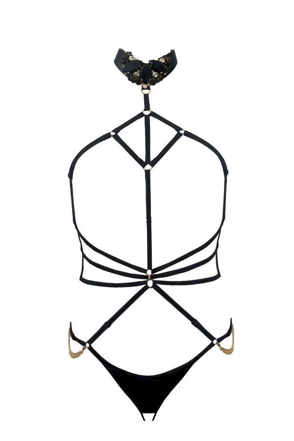 Open strappy Calypso playsuit with cage-style straps and provocative cut-outs, evoking a bondage-inspired aesthetic