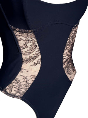 Luxury black lace bodysuit styled as statement lingerie for contemporary evening dressing.