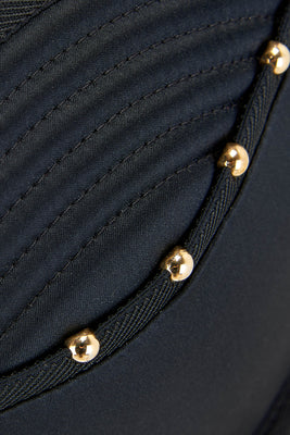 Close up details of gold studding and quilting on the Babooshka suspender 