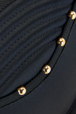 Detail of gold studs and quilting on the Babooshka deep plunge bra